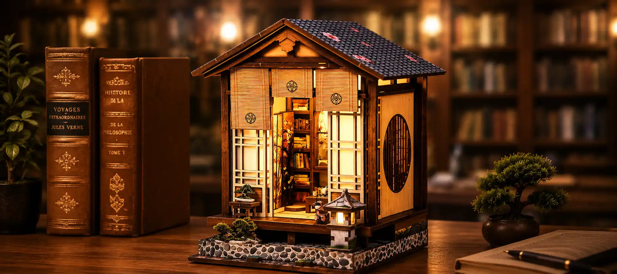 Kit book nook japonais en bois monté et éclairé, posé entre des livres anciens et un bonsaï
