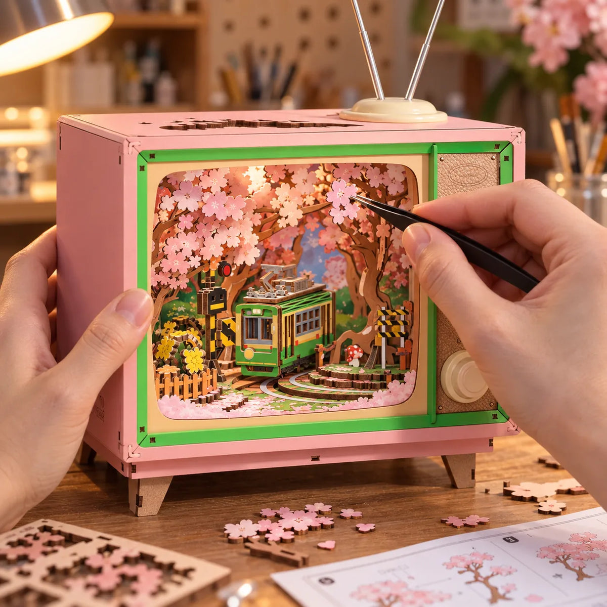 Pose des fleurs de cerisier dans le décor miniature de la boîte à musique