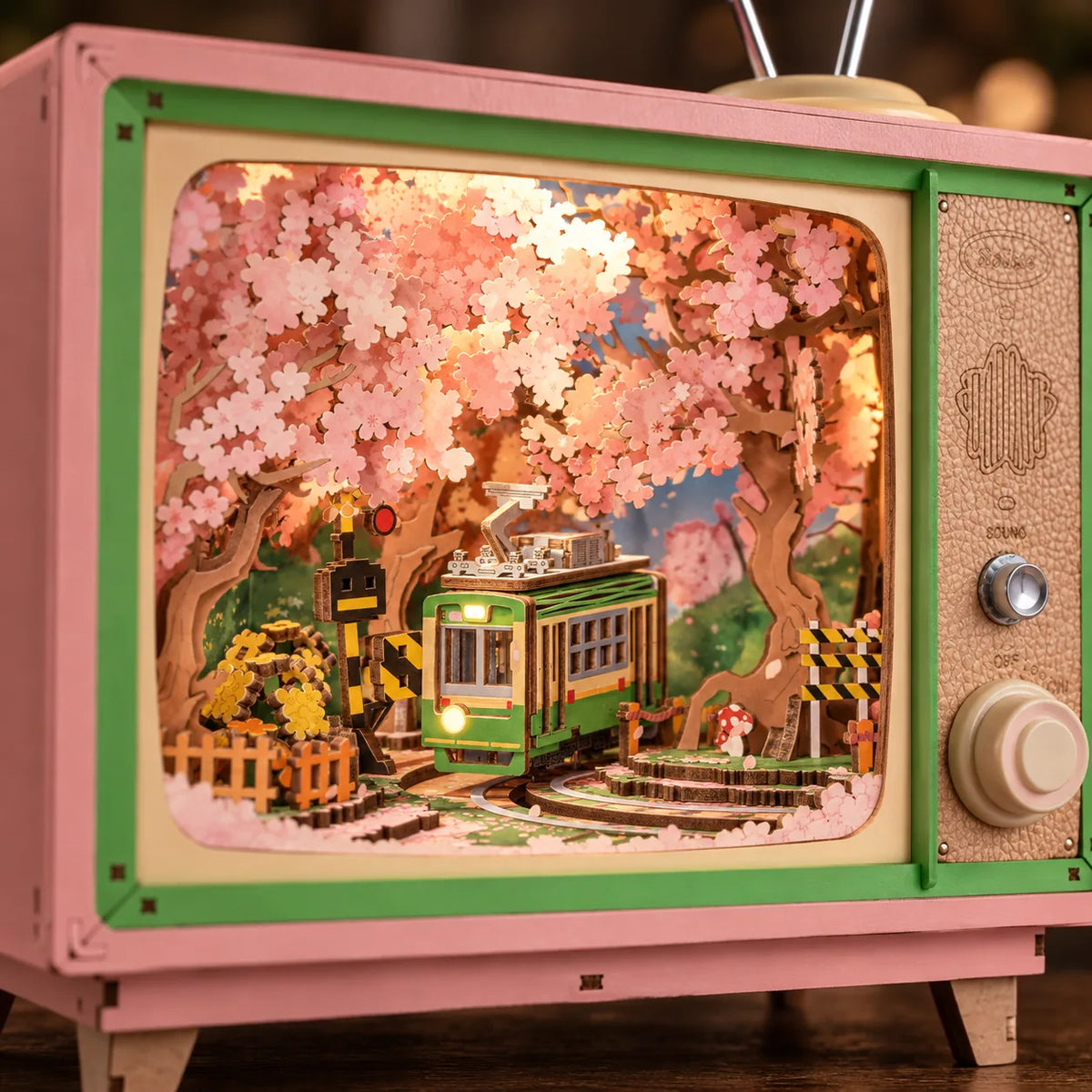 Détail du tram vert et des cerisiers illuminés dans la boîte à musique Sakura