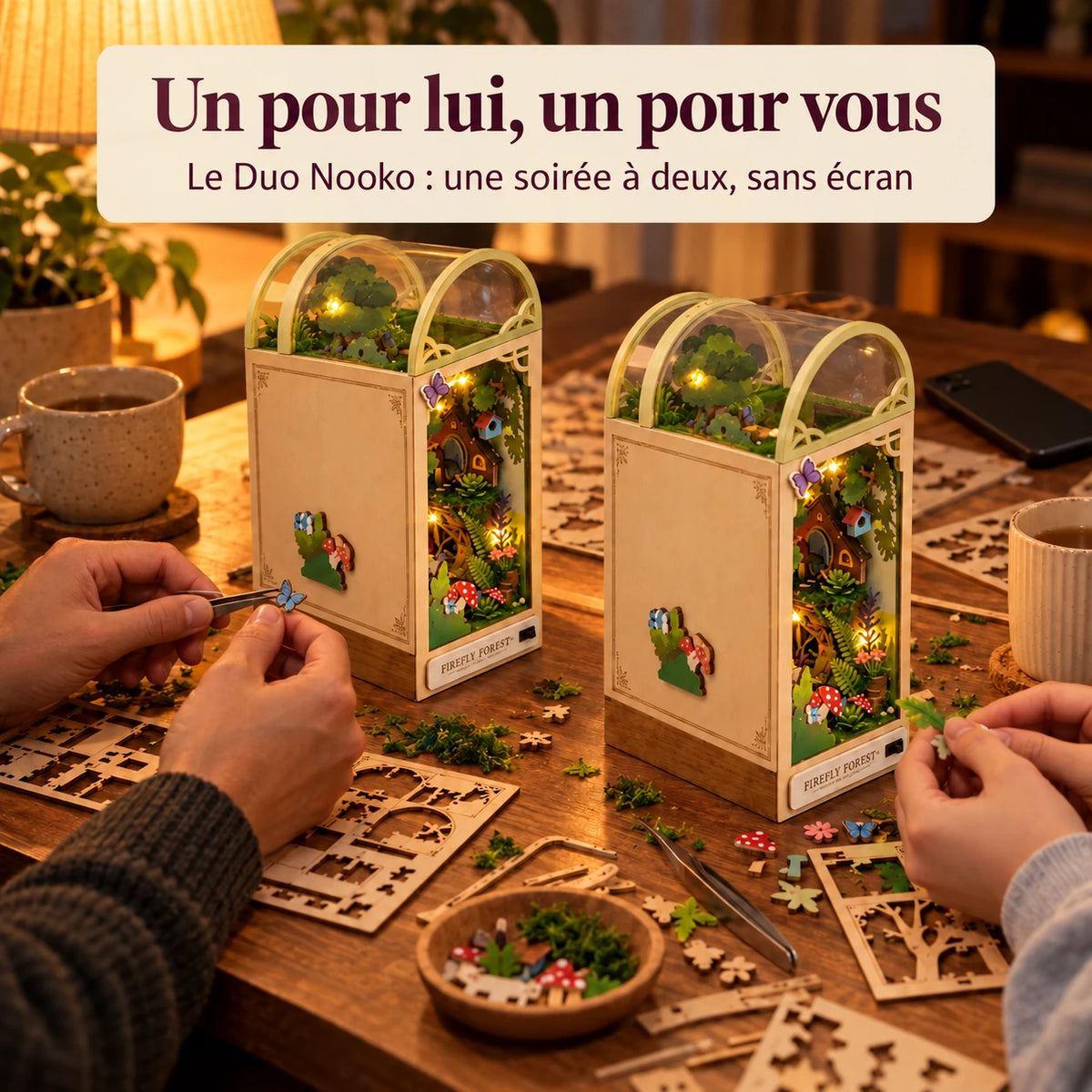 Un adulte et un adolescent montent chacun la Forêt des Lucioles sur un bureau