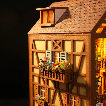 Détails en bois découpé du book nook alsacien : colombages et balcon fleuri