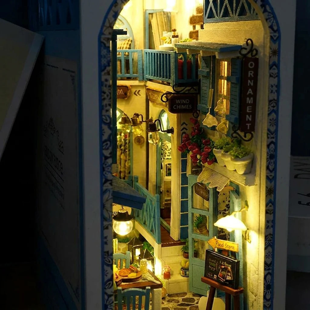 Gros plan du book nook Ruelle de Santorin, ruelle grecque illuminée la nuit, volets bleus et pierre blanche