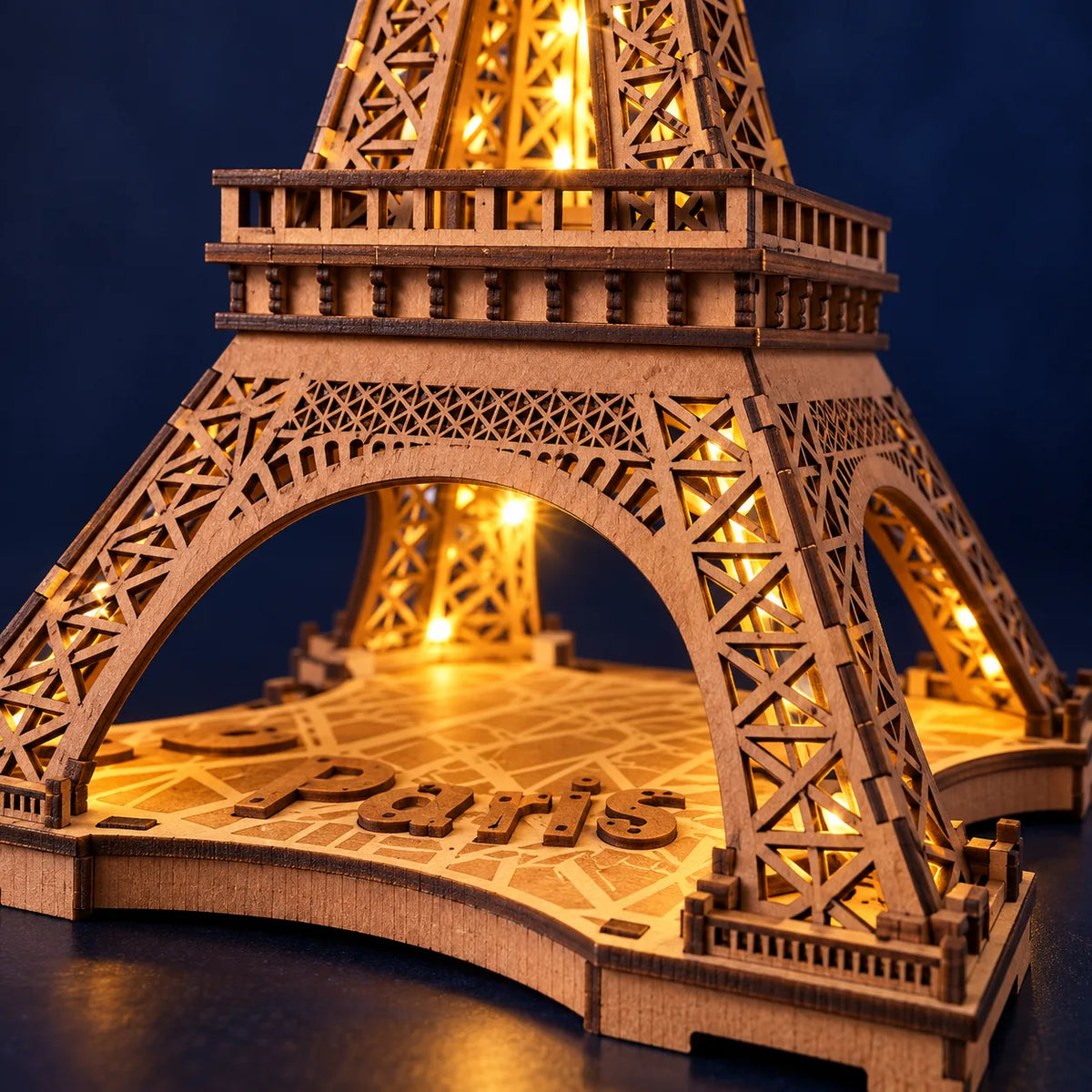 Détail de la base gravée Paris et du treillis illuminé de la Tour Eiffel