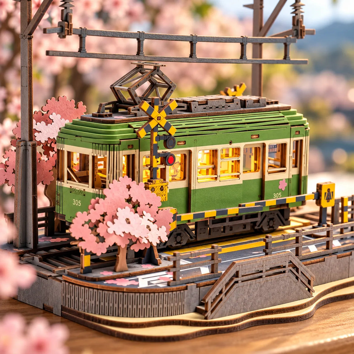 Détail du tram vert illuminé sous les cerisiers roses